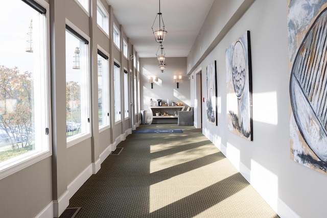 hall with dark colored carpet