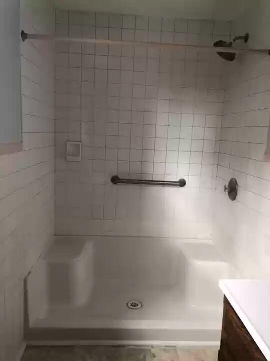 bathroom featuring a tile shower and vanity