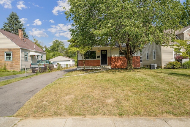 view of front of home with central AC unit and a front lawn