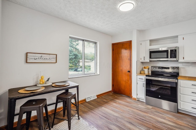 kitchen featuring backsplash, white cabinetry, and stainless steel appliances