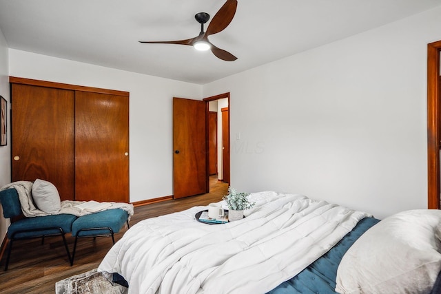 bedroom with a closet, dark hardwood / wood-style floors, and ceiling fan