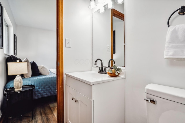 bathroom with wood-type flooring, toilet, and vanity