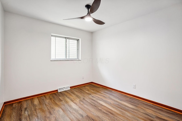 empty room with ceiling fan and hardwood / wood-style floors