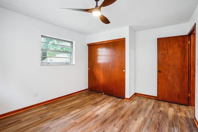 unfurnished bedroom with a closet, hardwood / wood-style floors, and ceiling fan