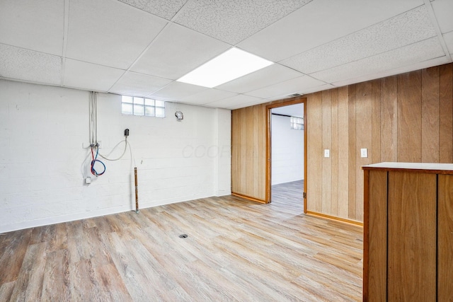 basement with light wood-type flooring and a drop ceiling