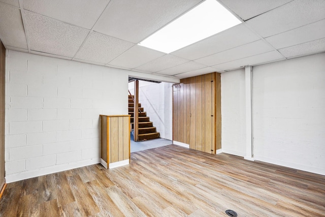 basement featuring light hardwood / wood-style flooring and a drop ceiling