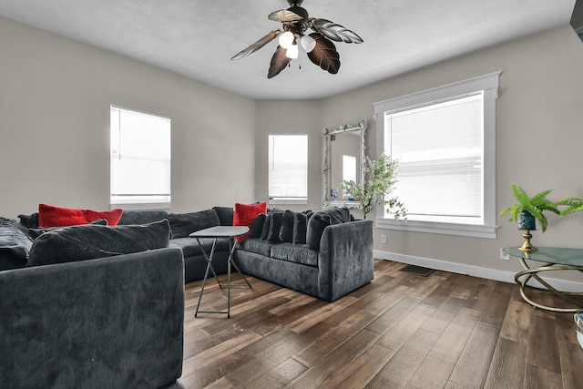 living room with ceiling fan and dark wood-type flooring