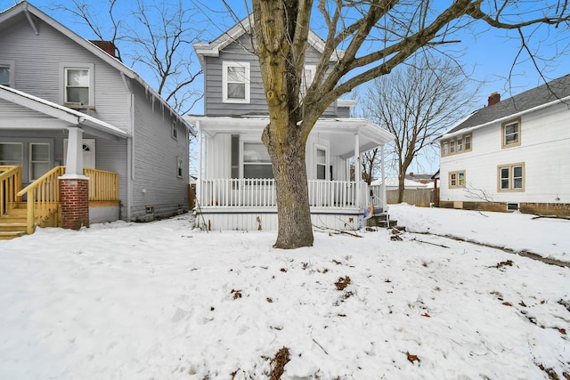 snow covered house featuring a porch