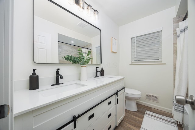 bathroom with toilet, wood-type flooring, and vanity