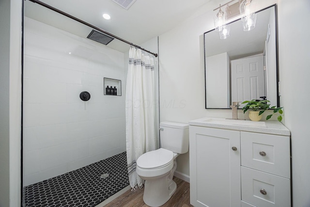 bathroom featuring toilet, vanity, curtained shower, and hardwood / wood-style flooring