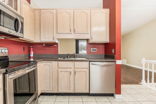 kitchen featuring light tile patterned floors, sink, light brown cabinets, and appliances with stainless steel finishes