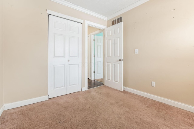 unfurnished bedroom featuring carpet floors, a closet, and ornamental molding