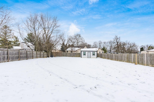 yard layered in snow featuring a shed