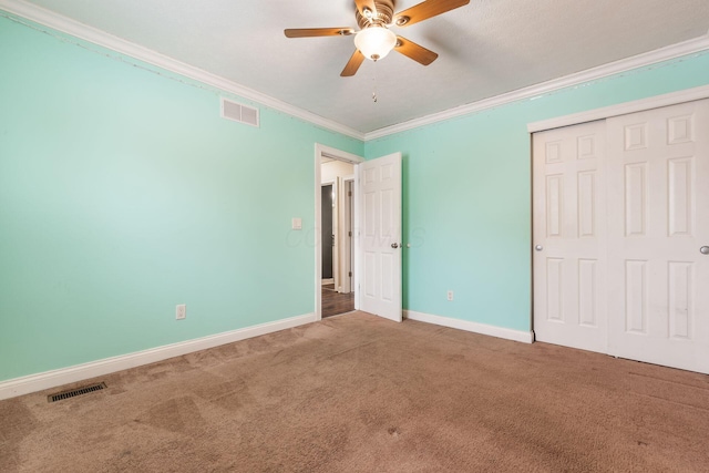 unfurnished bedroom featuring ceiling fan, a closet, carpet floors, and ornamental molding