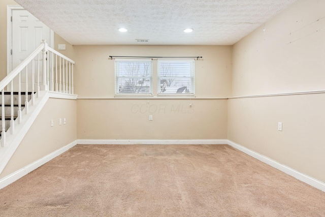 carpeted spare room featuring a textured ceiling