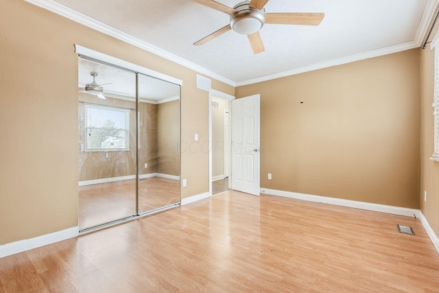 unfurnished bedroom with ceiling fan, a closet, ornamental molding, and light hardwood / wood-style flooring