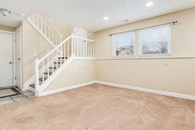 interior space with light colored carpet and a textured ceiling