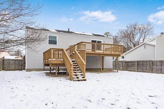 snow covered house featuring a wooden deck