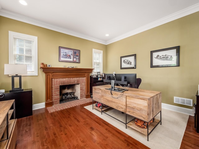 office space with a brick fireplace, dark hardwood / wood-style floors, and crown molding