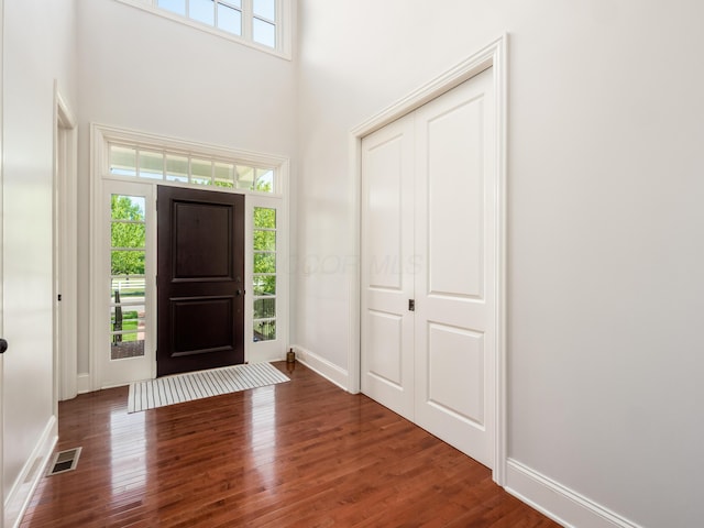 entrance foyer with dark hardwood / wood-style flooring and a high ceiling