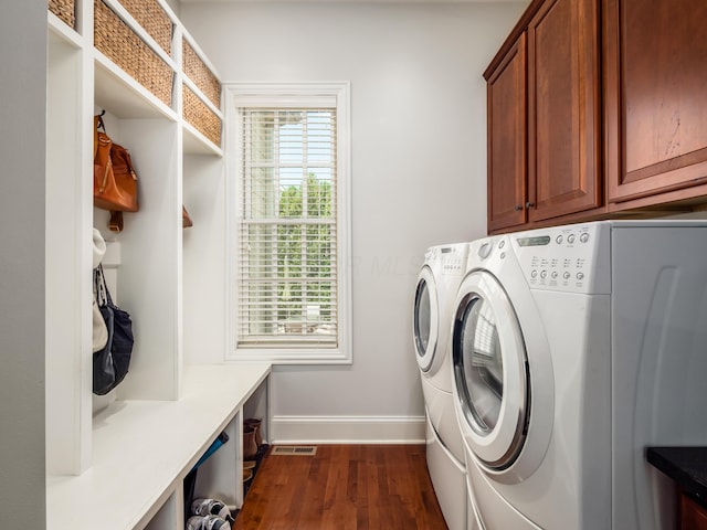 laundry room featuring dark wood-type flooring, cabinets, and independent washer and dryer