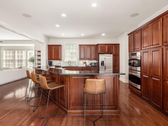 kitchen with plenty of natural light, appliances with stainless steel finishes, a breakfast bar area, and a kitchen island