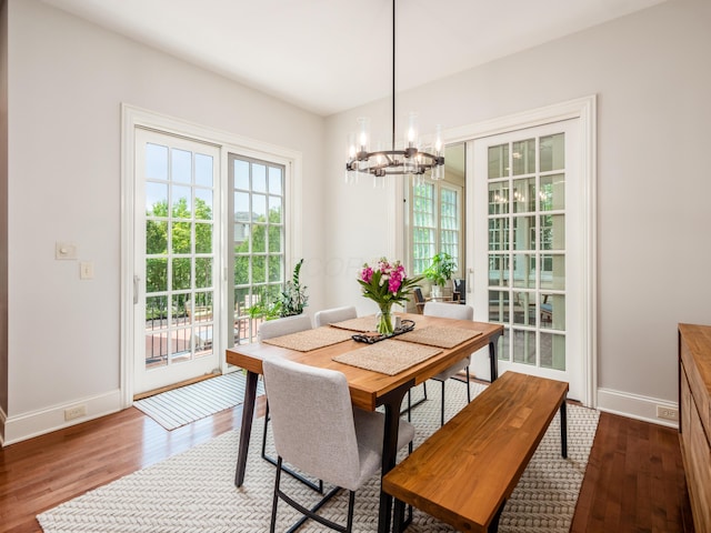 dining area with wood-type flooring and a chandelier