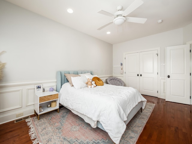 bedroom featuring ceiling fan, dark hardwood / wood-style floors, and a closet