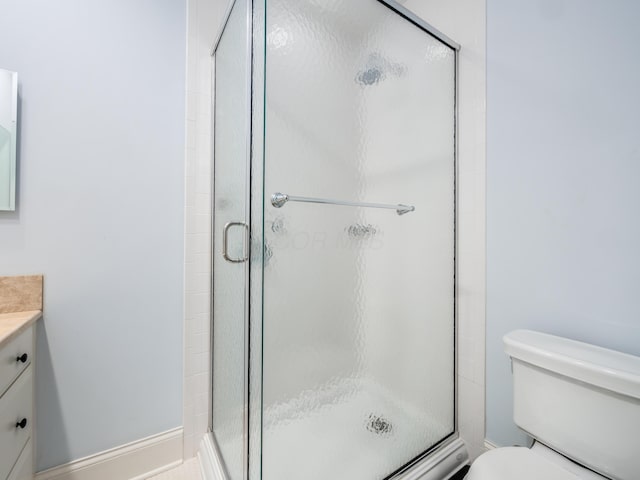 bathroom featuring walk in shower, vanity, and toilet