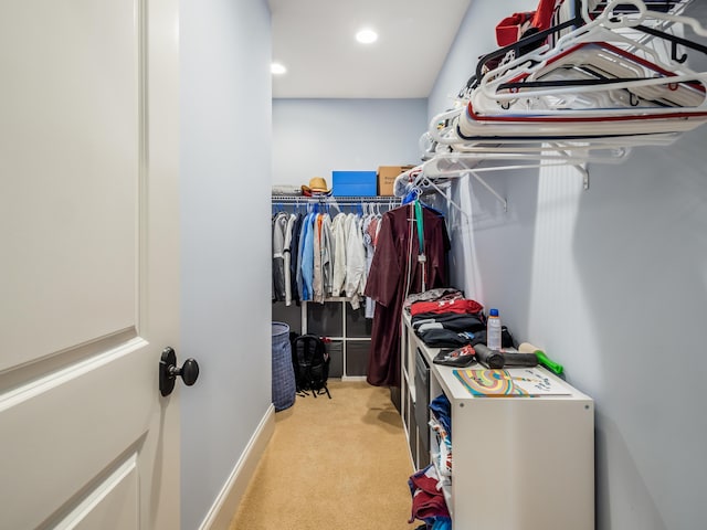 walk in closet featuring light carpet