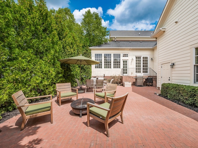 view of patio / terrace with grilling area, french doors, and a fire pit