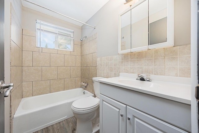 full bathroom with toilet, vanity, tiled shower / bath combo, decorative backsplash, and hardwood / wood-style flooring