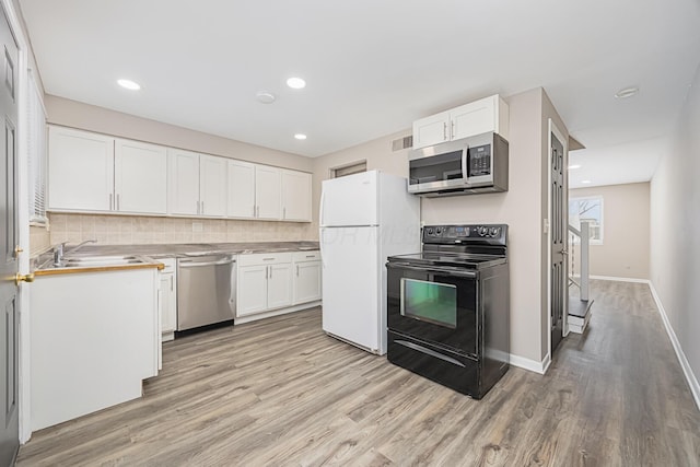 kitchen with sink, white cabinets, stainless steel appliances, and light wood-type flooring