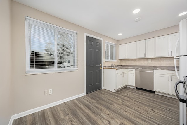 kitchen with backsplash, dark wood-type flooring, white refrigerator, stainless steel dishwasher, and white cabinets