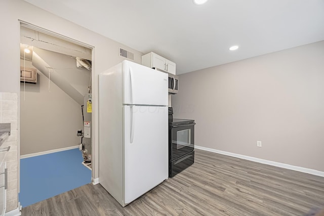 kitchen with white refrigerator, white cabinets, hardwood / wood-style flooring, and black range with electric stovetop