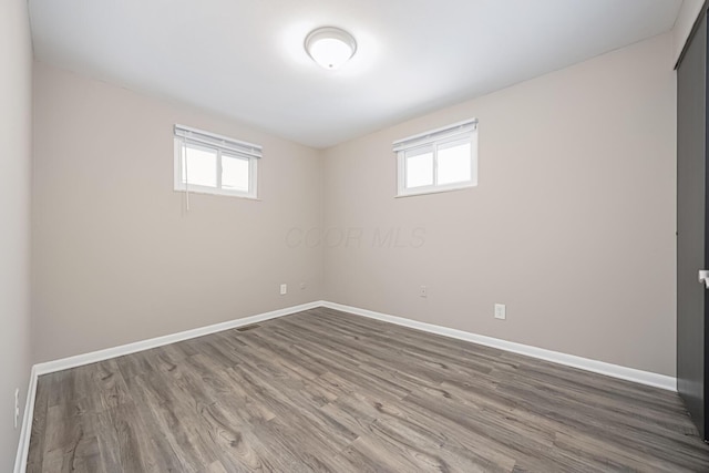 basement with a healthy amount of sunlight and hardwood / wood-style floors