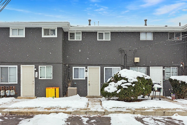 snow covered rear of property with central AC unit