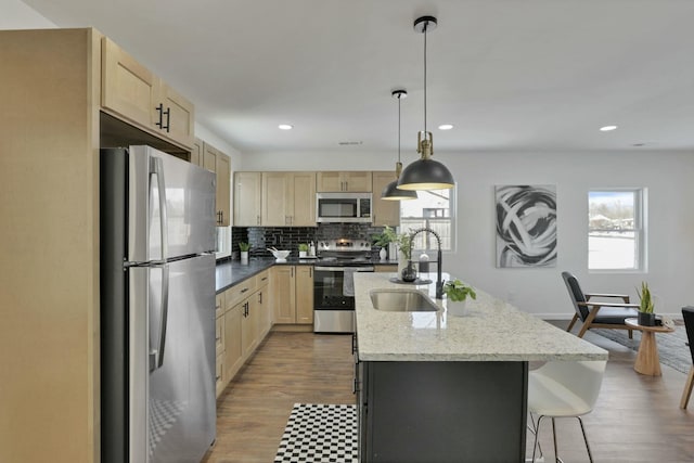 kitchen featuring stainless steel appliances, plenty of natural light, sink, and decorative light fixtures