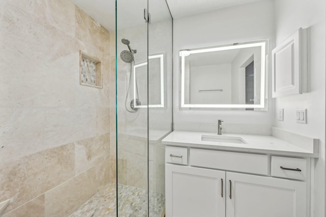 bathroom with vanity and tiled shower