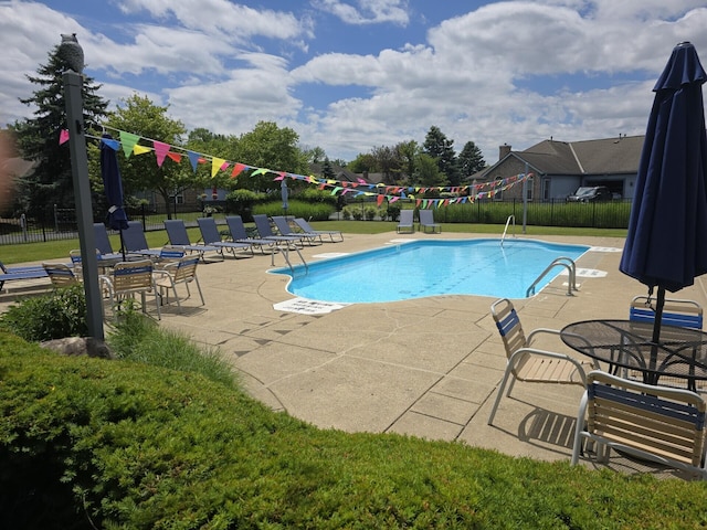 community pool with fence and a patio