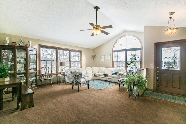 carpeted living room featuring ceiling fan, lofted ceiling, and a textured ceiling