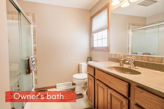 bathroom with walk in shower, vanity, and toilet