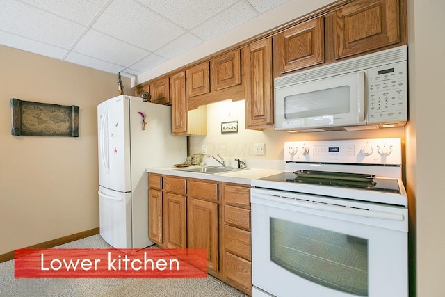 kitchen with a drop ceiling, sink, and white appliances