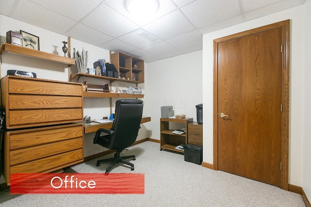 carpeted office featuring built in desk and a drop ceiling