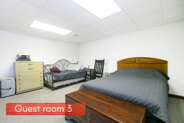 carpeted bedroom with a drop ceiling