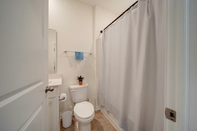 bathroom featuring toilet, a shower with shower curtain, and vanity