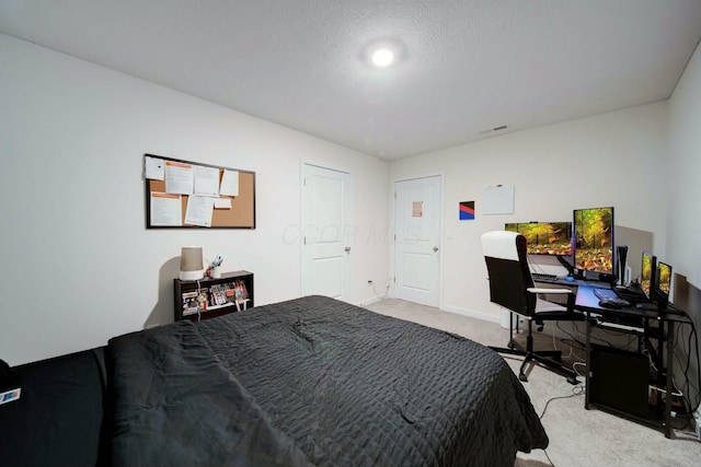 bedroom featuring a textured ceiling and light carpet