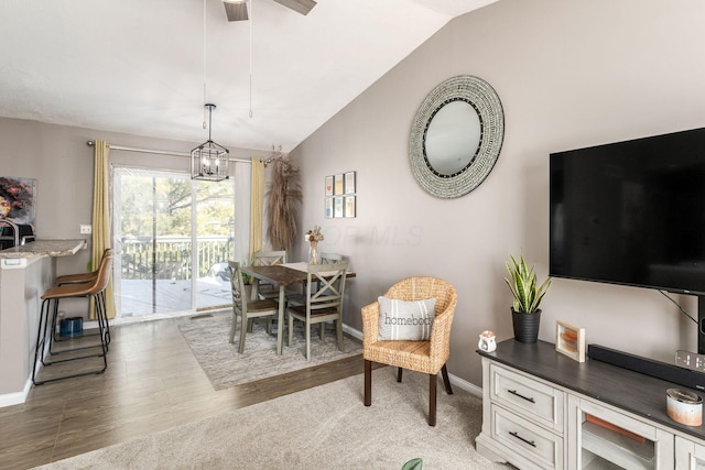 dining area featuring ceiling fan with notable chandelier and lofted ceiling