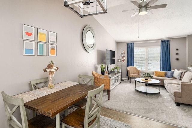 dining space featuring ceiling fan, vaulted ceiling, a textured ceiling, and hardwood / wood-style flooring