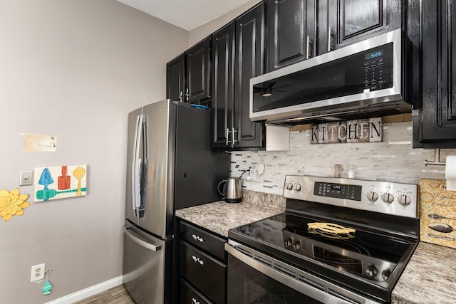 kitchen featuring appliances with stainless steel finishes, decorative backsplash, hardwood / wood-style flooring, and light stone countertops